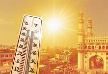Thermometer showing high temperature at sunset with historic cityscape in the background.