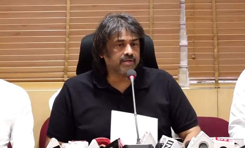 Prominent speaker at a press conference addressing media questions in a professional setting.
