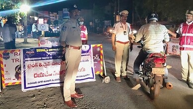 Police officers managing traffic at night with warning signs in the background, ensuring safety and order.