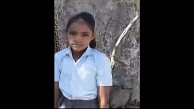 Young girl in school uniform sitting near a tree, showing the impact of stray dog attack in Rajasthan.