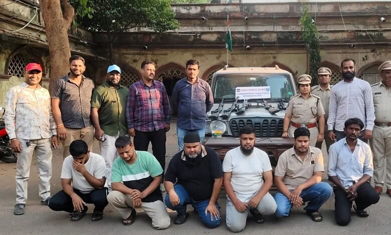 Group of men and police officers posing with seized vehicles after illegal deer and peacock hunting in Te.