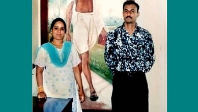 Two individuals standing in front of a mural, related to the 2005 fake encounter of Sohrabuddin Shaikh.