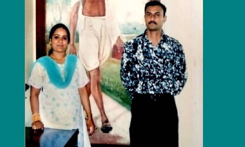 Two individuals standing in front of a mural, related to the 2005 fake encounter of Sohrabuddin Shaikh.
