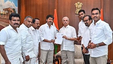 Politicians in white attire exchanging documents in a government office, symbolising political collaborat.