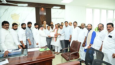 Group of Indian men in formal attire gathered in an office for a meeting or award presentation.