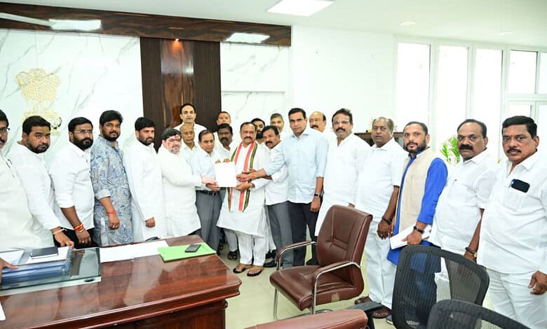 Group of Indian men in formal attire gathered in an office for a meeting or award presentation.
