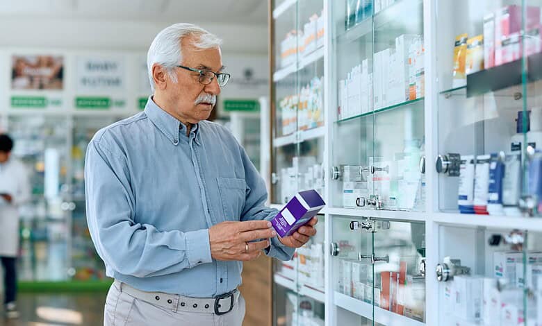 A woman in a pharmacy examining medication boxes on a shelf.