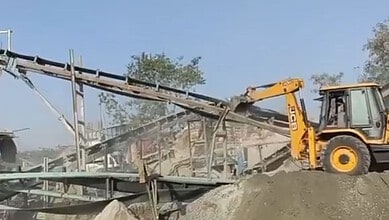 Excavator demolishing illegal mining structures in Hyderabad as part of anti-mining operations.