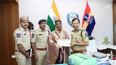 Police officers with official uniforms and a man receiving an award in an office setting.
