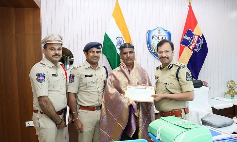 Police officers with official uniforms and a man receiving an award in an office setting.