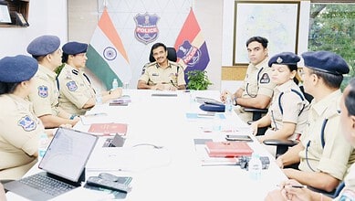 Police officers in uniform attending a meeting in a police station conference room.