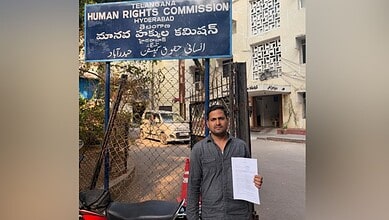 Man holding document outside Hyderabad Human Rights Commission office after Madinah bus accident.