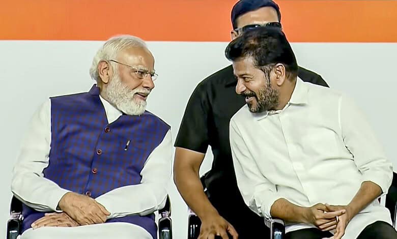 Indian Prime Minister Narendra Modi smiling and engaging with Telangana Chief Minister Revanth Reddy duri.