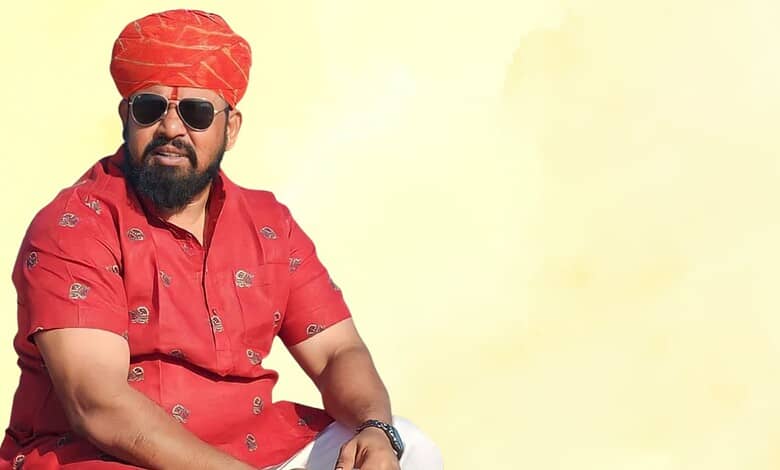 Celebrating Indian culture with a man in traditional red attire and turban, wearing sunglasses, against a.