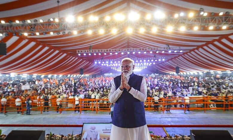 Prime Minister Narendra Modi at Parade Grounds in Telangana, delivering a bold speech with a large crowd.