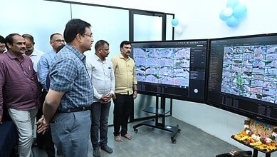A detailed group of professionals analysing satellite imagery on large screens during a technical present.