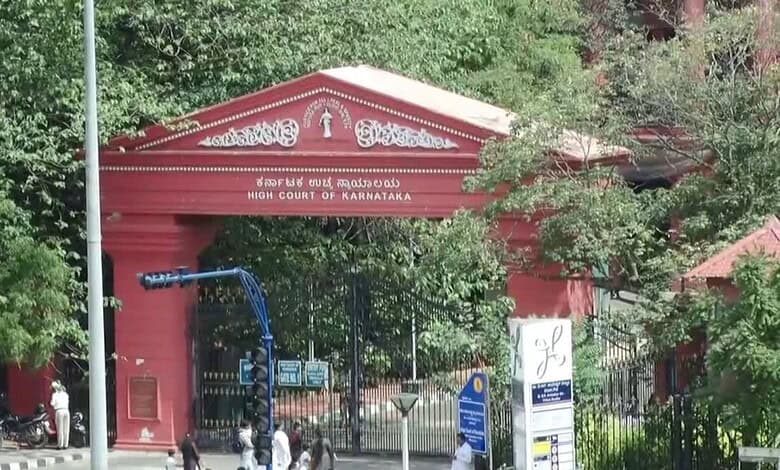 High Court of Karnataka entrance gate in Bangalore, surrounded by greenery and official signage.