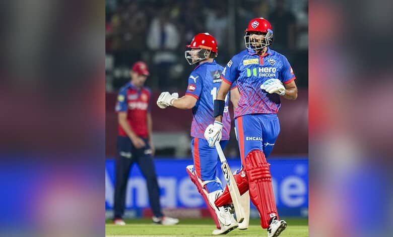 A cricket players celebrating on the field during an IPL match, wearing blue and red uniforms.