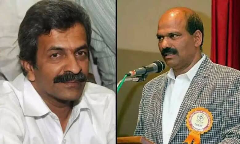 A man with a moustache and white shirt, and another man in a checked blazer speaking at a microphone duri.