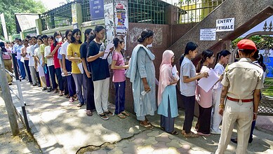 Candidates standing in long queue outside an exam centre, waiting to enter for NEET exam amid paper leak.