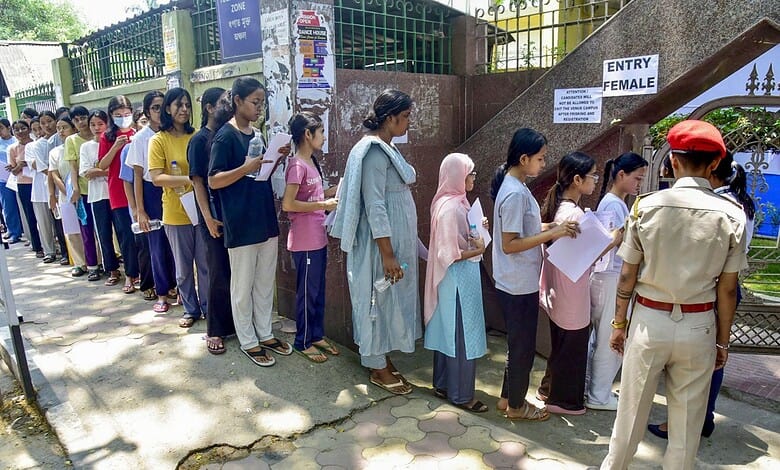 Candidates standing in long queue outside an exam centre, waiting to enter for NEET exam amid paper leak.