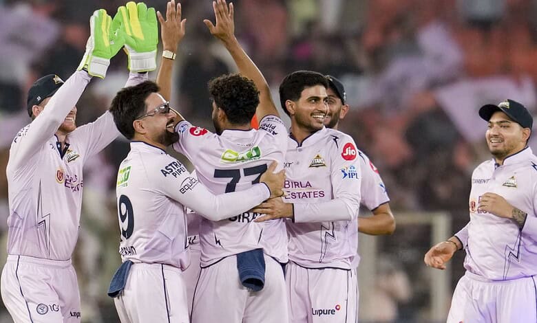 Celebrating cricket victory, Indian team players in white uniforms joyfully embrace on the field.