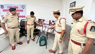 A man in police uniform with officers examining evidence related to burglary case in Hyderabad.