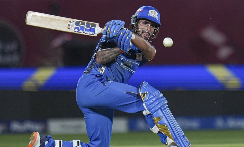 A cricket player in blue uniform hitting the ball with a bat during a match.