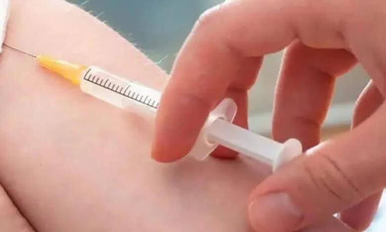 Vaccination injection being administered into a person's arm with a syringe.
