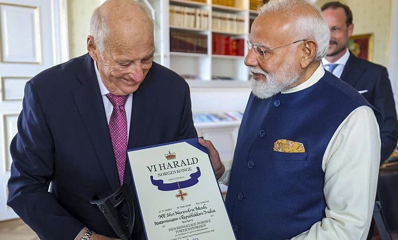 Honourable elderly man receiving award from Indian Prime Minister Narendra Modi at a formal event in Indi.
