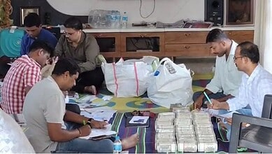 ACB officials count cash seized from the general manager's house