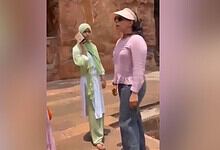 Sunset conversation between two women outdoors, one wearing a hijab and the other in casual attire, in a.