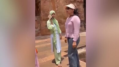 Sunset conversation between two women outdoors, one wearing a hijab and the other in casual attire, in a.