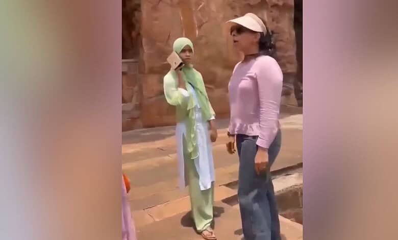 Sunset conversation between two women outdoors, one wearing a hijab and the other in casual attire, in a.
