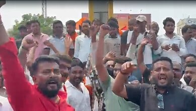 Protesters protesting passionately with raised fists and shouting during a demonstration in an urban area.