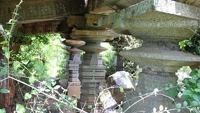 Ancient Kakatiya-era Warangal temple ruins with stone pillars and lush greenery, highlighting historical.