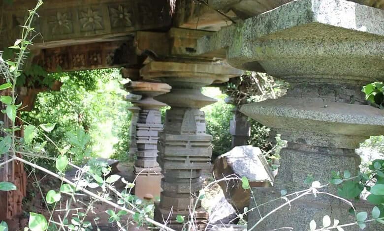 Ancient Kakatiya-era Warangal temple ruins with stone pillars and lush greenery, highlighting historical.