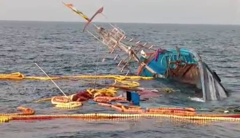 A sinking fishing boat off Goa coast with 22 fishermen rescued in the background.
