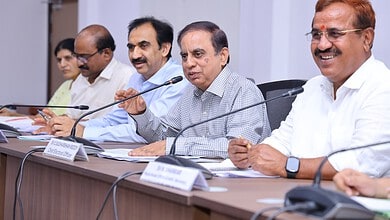 Senior officials and government representatives seated at a conference table during a formal meeting.