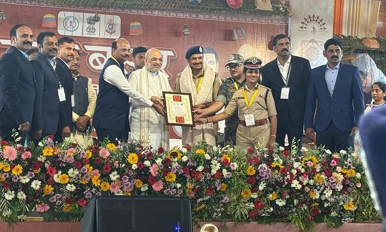 Prominent leaders and officials at a formal event with floral arrangements and a certificate presentation.