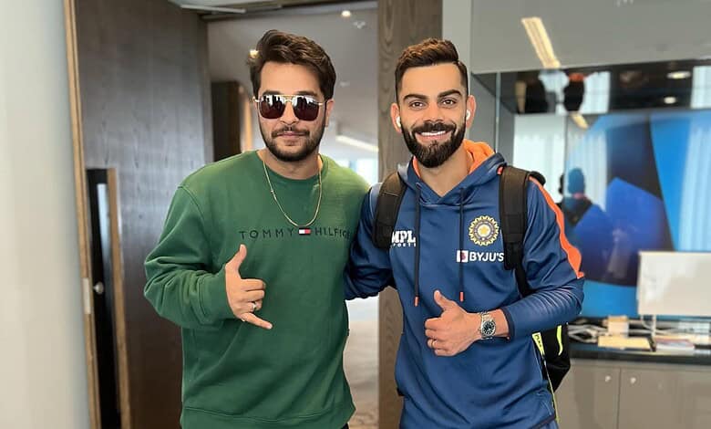Asim Azhar and Virat Kohli smiling together at an airport, showcasing celebrity interaction and sports en.