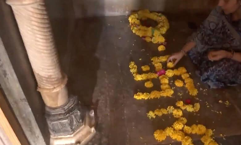 Diwali ritual with flower petals and candles on the floor, person arranging flowers for festival prayers,.