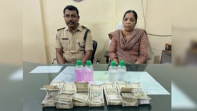 Bribe exchange caught on camera involving Telangana forest officials with cash and bottles on a table.