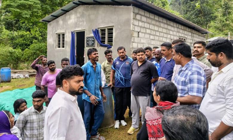 Community members and leaders engaged in discussion outside a modest rural home.