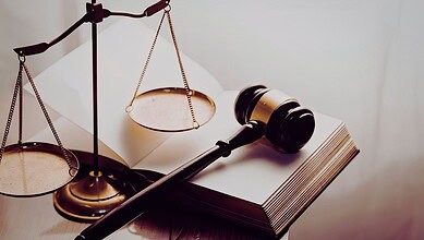 Image showing a gavel and scales of justice on a legal book, representing law, justice, and legal proceedings.