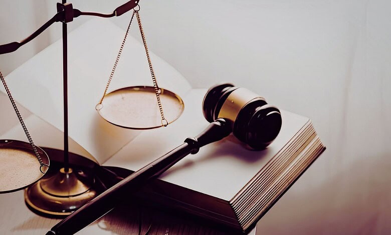 Image showing a gavel and scales of justice on a legal book, representing law, justice, and legal proceedings.
