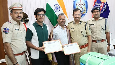 Police officials with two men holding certificates in Hyderabad.