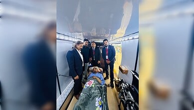 Seriously ill Indian man lies on a stretcher inside an aircraft with Embassy officials in Riyadh before repatriation to India.