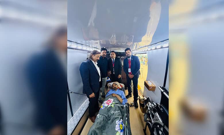 Seriously ill Indian man lies on a stretcher inside an aircraft with Embassy officials in Riyadh before repatriation to India.