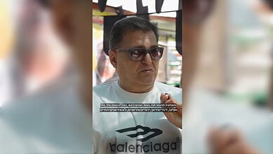 Man wearing sunglasses and a Balenciaga t-shirt, speaking about Iranian Jews in Shiraz.